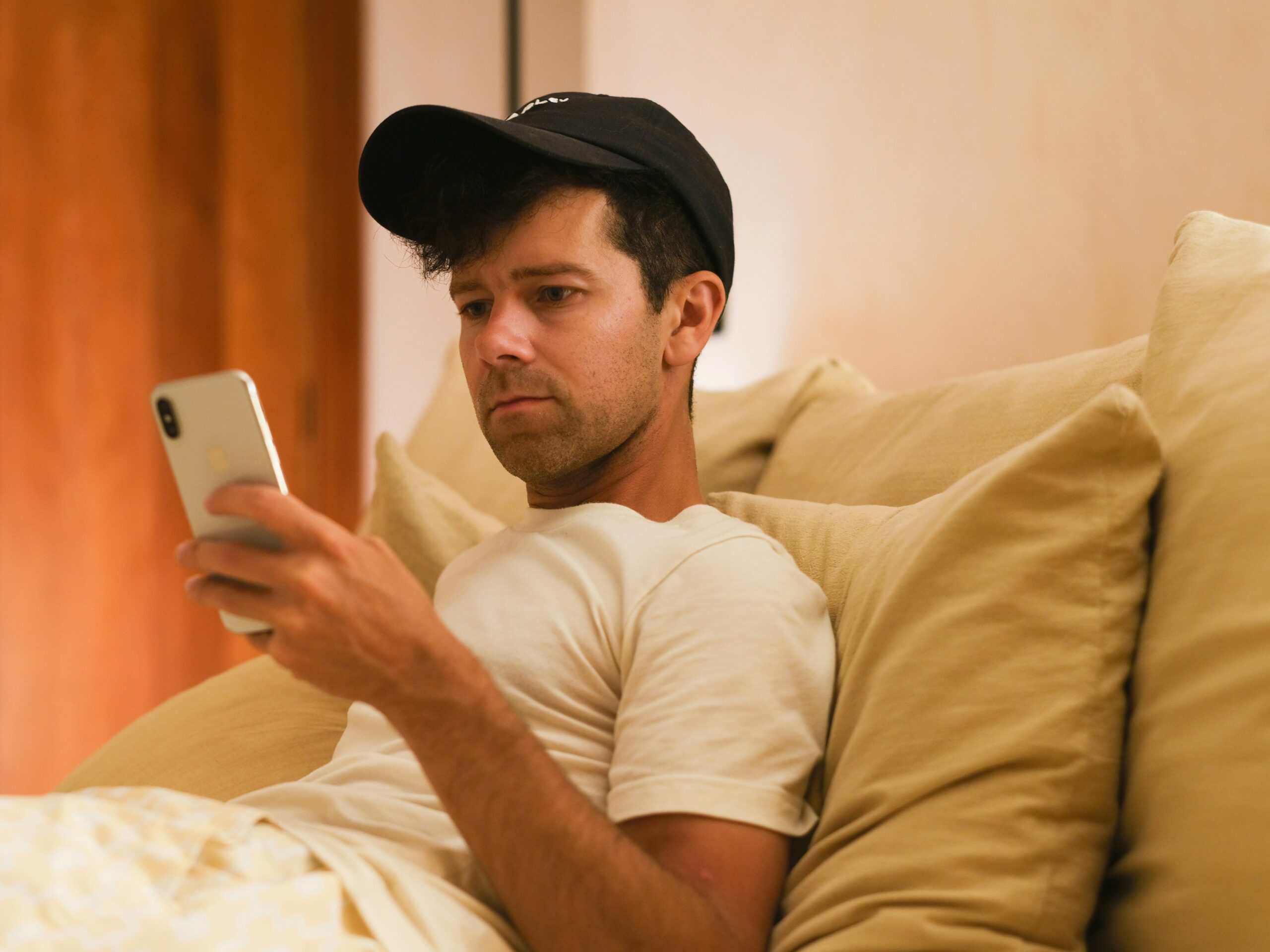 A frustrated person sitting on a couch looking at their phone