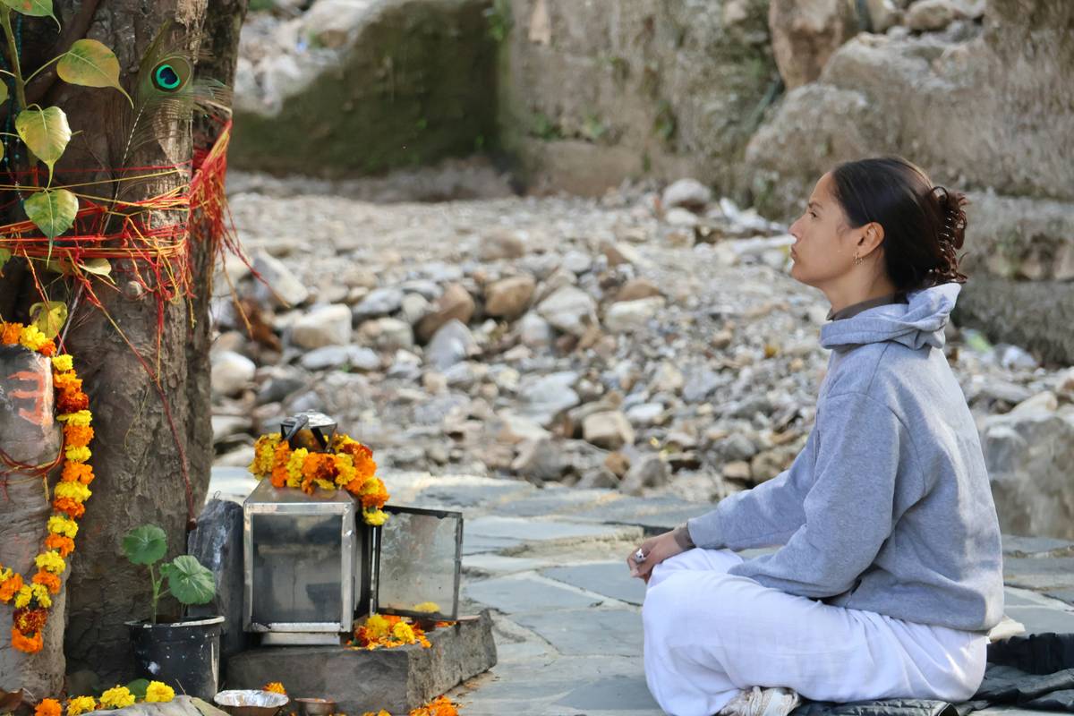 Woman practicing yoga near a lake, focusing on her breath