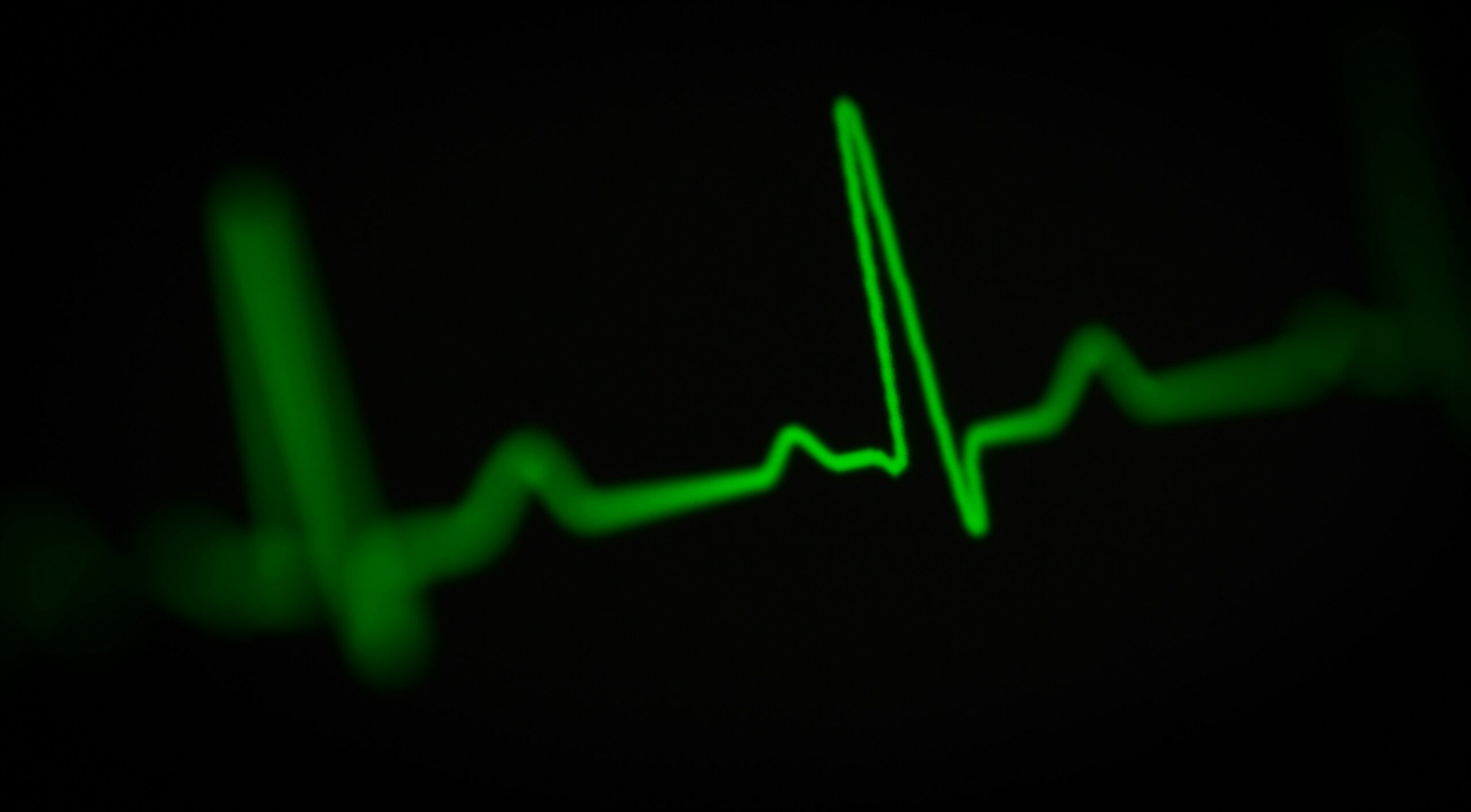 a green heart beat on a black background